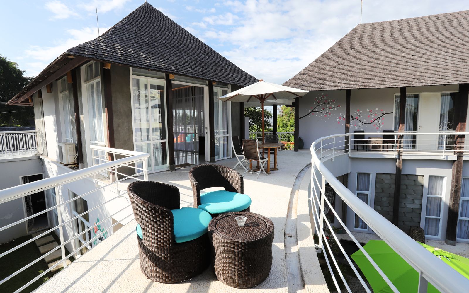 Stylish resort terrace in Bali featuring modern furniture and scenic outdoor view.